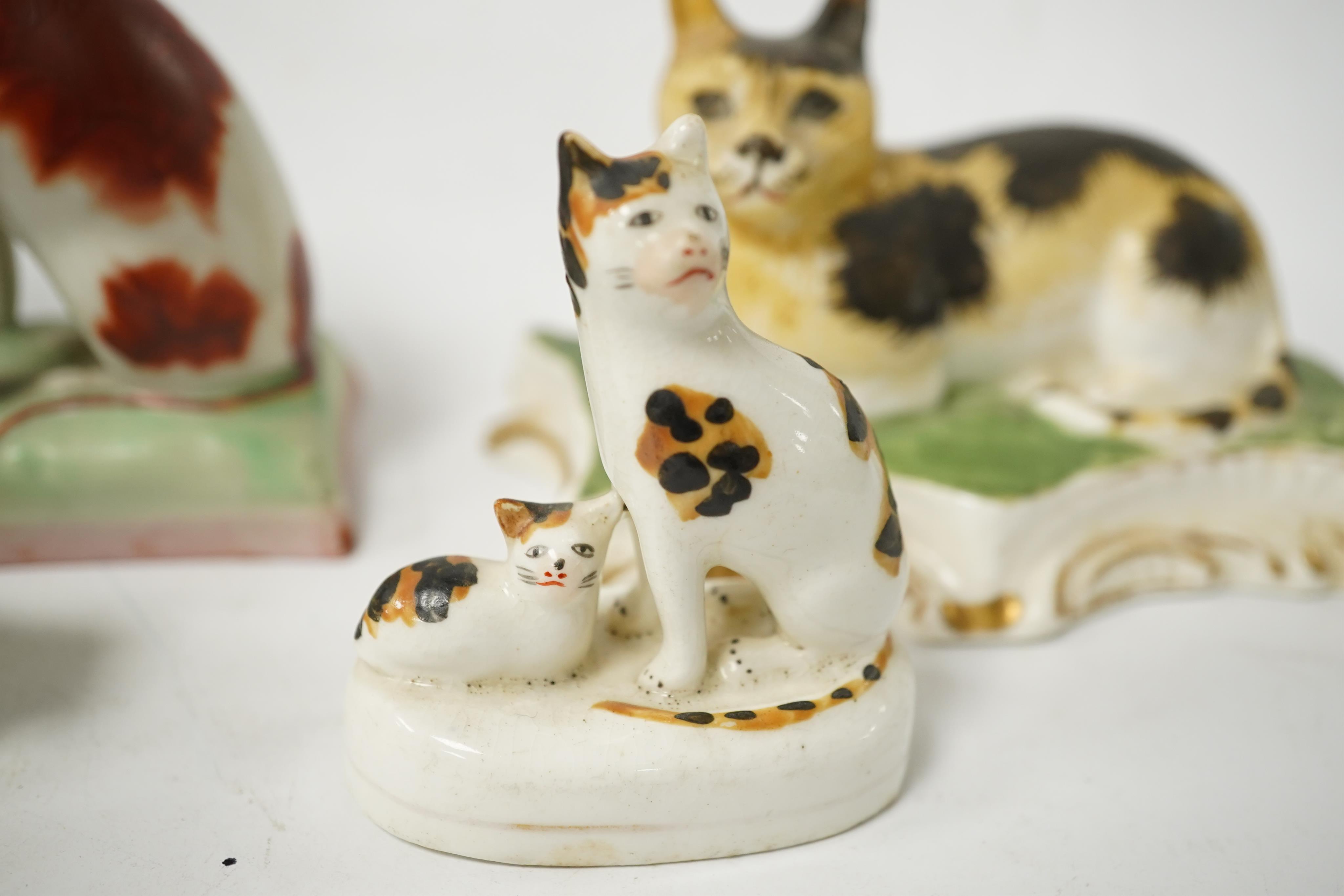 Five rare Staffordshire porcelain models of cats, circa 1830-50, including a group of a cat and kitten, together with a pair of late Staffordshire porcellaneous cats, Condition - restoration to three of the cats and a cr